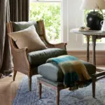 Chester Chair in aged green upholstery with whitewashed ash wood and woven detailing, styled with cushions in a light-filled living room.