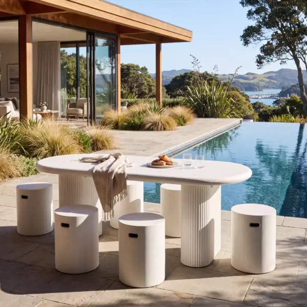 The Solona Outdoor Concrete Table pairs a strong architectural form with softened curves. Its generous rectangular top features rounded ends and a smooth bullnose edge, supported by two substantial ribbed pedestal bases that give the table its distinctive sculptural profile.